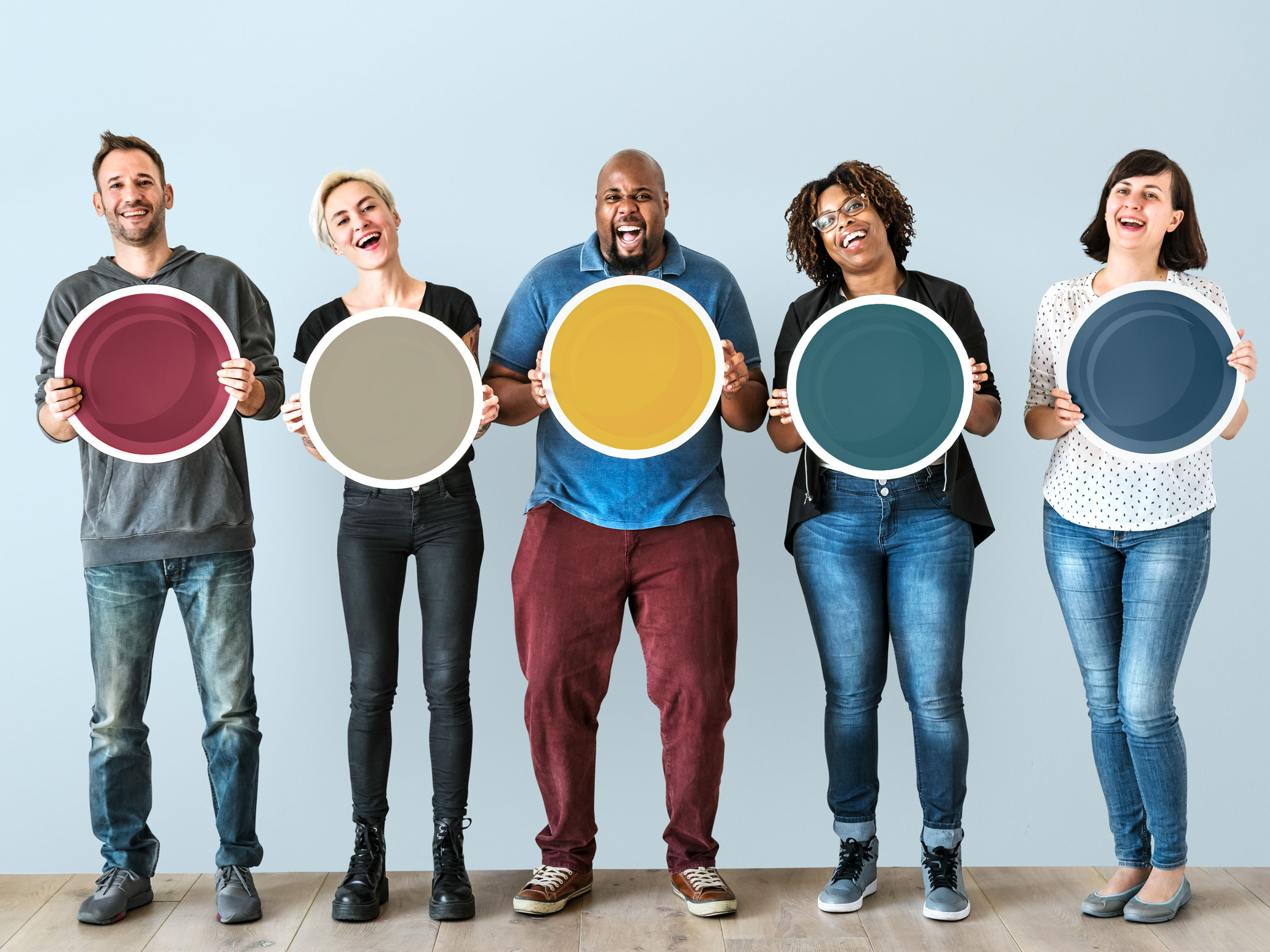 People standing holding colored circles and smiling